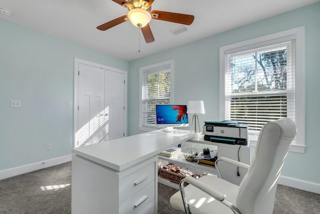 carpeted office with baseboards, visible vents, and ceiling fan