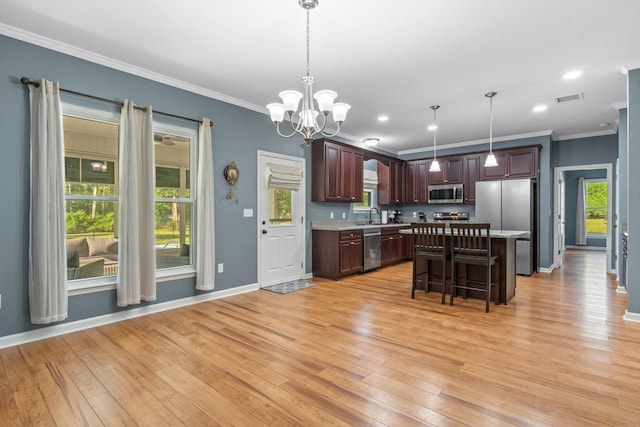 1094 Paul Thompson Rd, Monticello, FL 32344 - kitchen with appliances with stainless steel finishes, light countertops, light wood finished floors, crown molding, and a center island