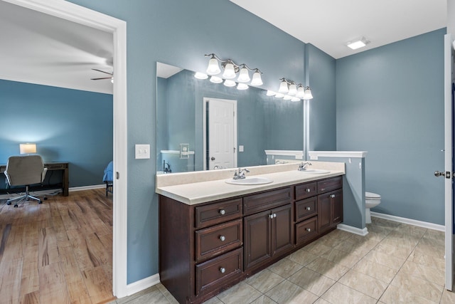 1094 Paul Thompson Rd, Monticello, FL 32344 - full bath with double vanity, toilet, a ceiling fan, and baseboards