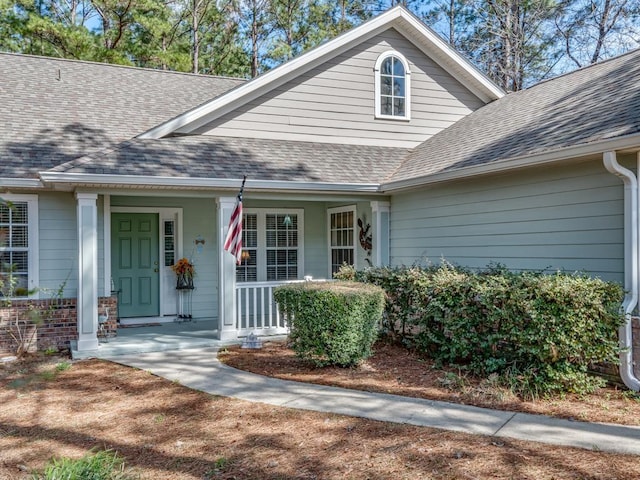 property entrance with a porch and roof with shingles