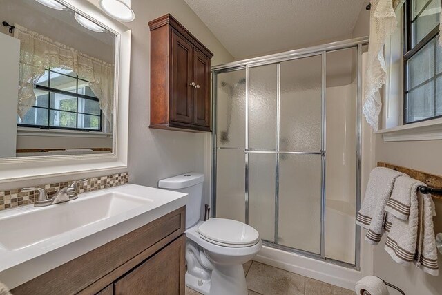 8709 Waltham Ct, Tallahassee, FL 32311 - bathroom featuring a stall shower, toilet, vanity, tile patterned flooring, and decorative backsplash
