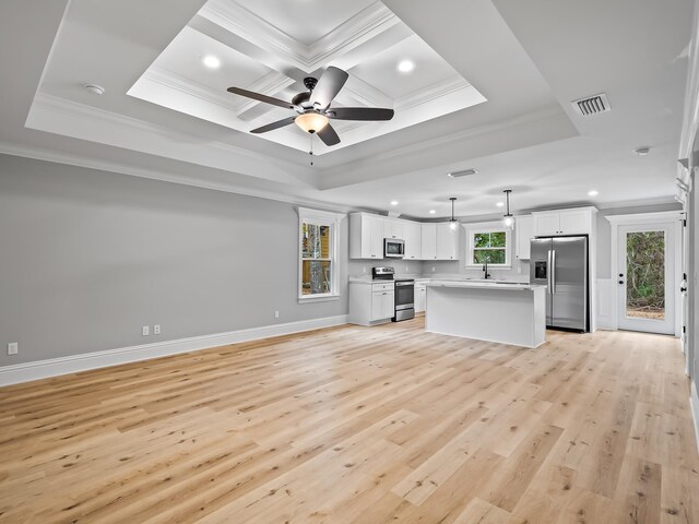 unfurnished living room with light hardwood / wood-style flooring, sink, crown molding, and a tray ceiling