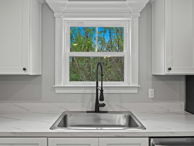 kitchen with white cabinets, light stone countertops, sink, and dishwasher