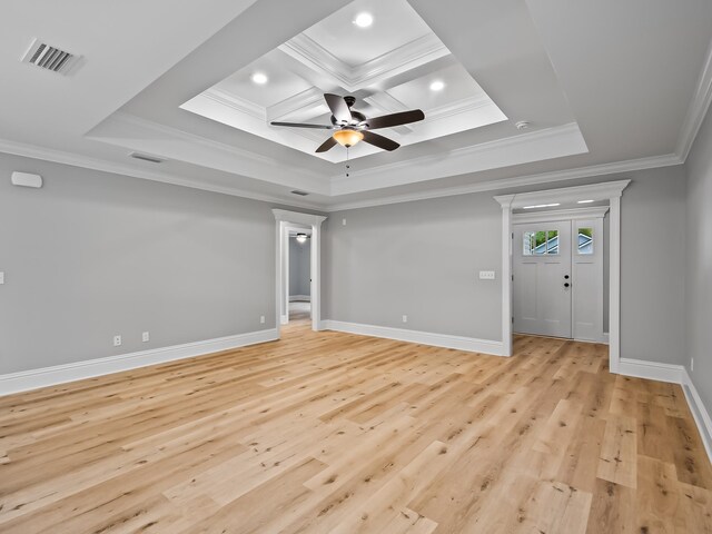 spare room featuring ornamental molding, light hardwood / wood-style flooring, ceiling fan, and a tray ceiling