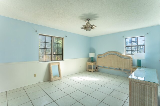 unfurnished bedroom with a textured ceiling and tile patterned flooring
