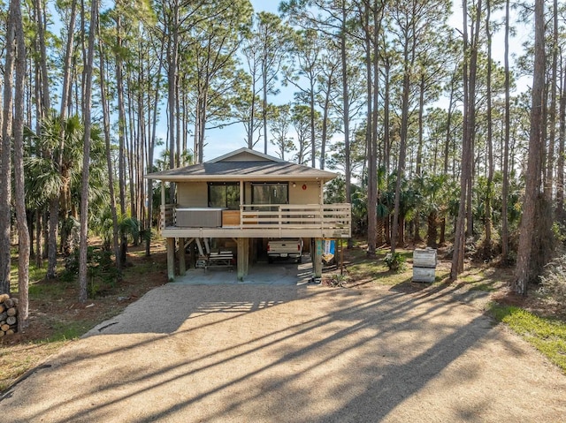 view of front of home with a carport, driveway, and a wooden deck