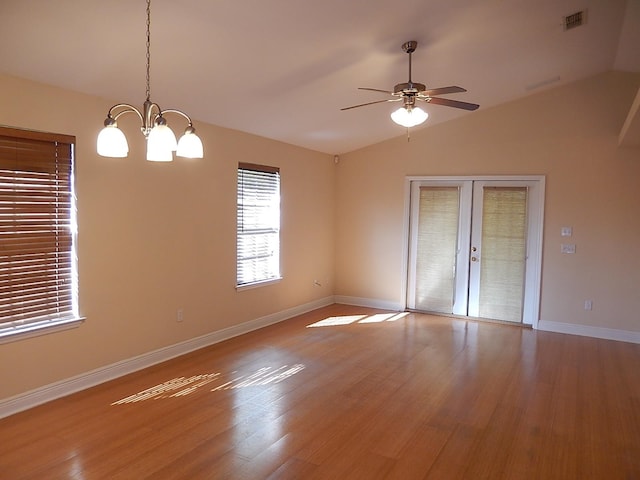 interior space featuring french doors, ceiling fan with notable chandelier, light hardwood / wood-style flooring, and vaulted ceiling