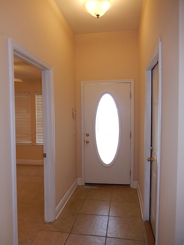 doorway to outside with light tile patterned flooring