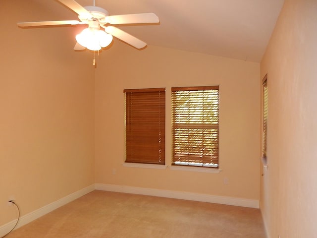 spare room featuring ceiling fan, light colored carpet, and lofted ceiling