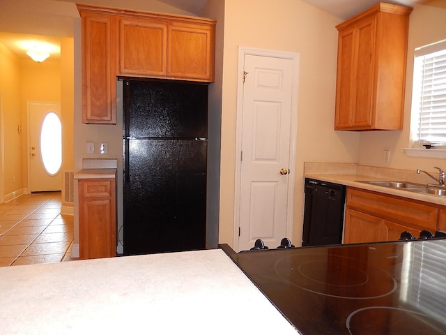 kitchen with light tile patterned floors, sink, and black appliances