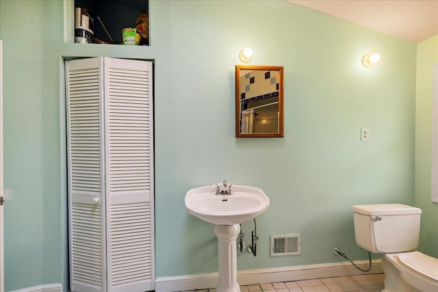 bathroom with toilet, a closet, visible vents, and baseboards