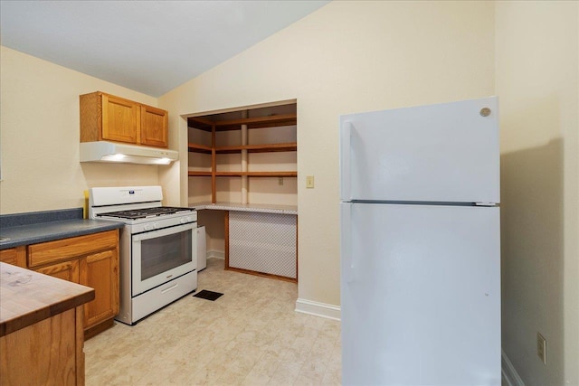 kitchen with light floors, lofted ceiling, brown cabinetry, white appliances, and under cabinet range hood