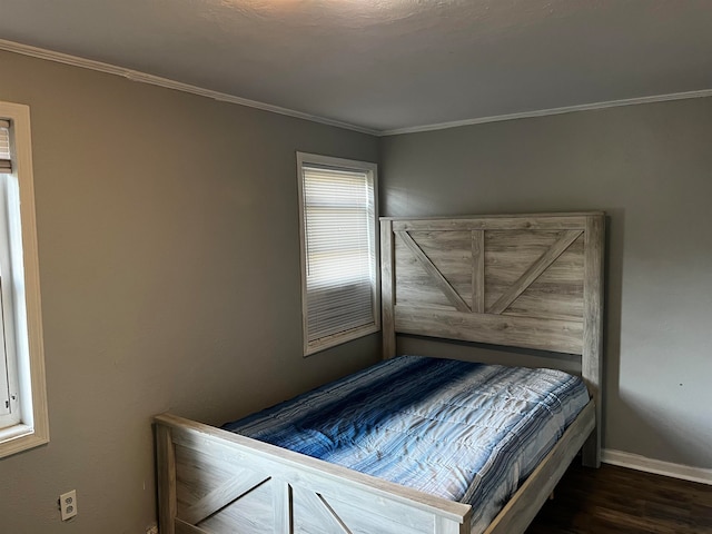 bedroom with dark hardwood / wood-style floors and ornamental molding