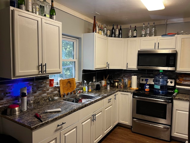 kitchen featuring appliances with stainless steel finishes, backsplash, crown molding, sink, and white cabinetry