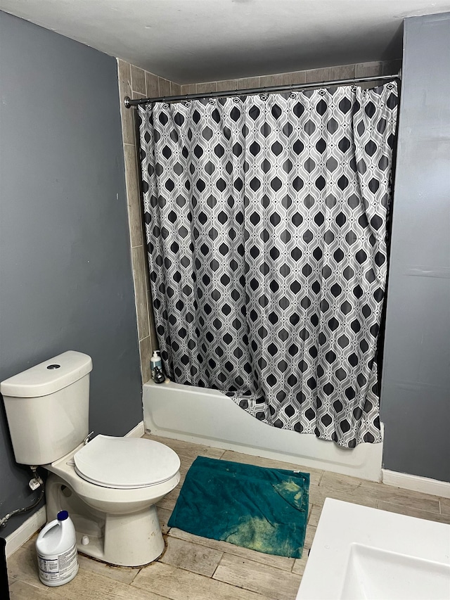 bathroom with hardwood / wood-style flooring, toilet, and shower / tub combo with curtain