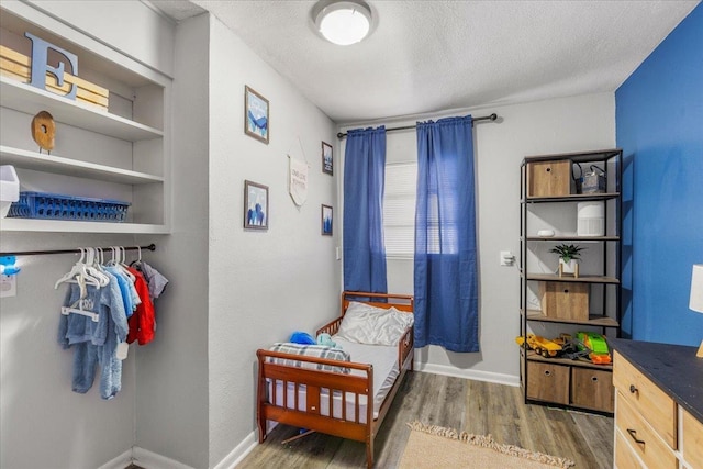 bedroom with dark wood-type flooring and a textured ceiling