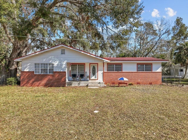 ranch-style house with a porch, a trampoline, and a front yard