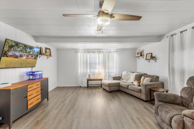 living room with beam ceiling, light hardwood / wood-style flooring, and ceiling fan