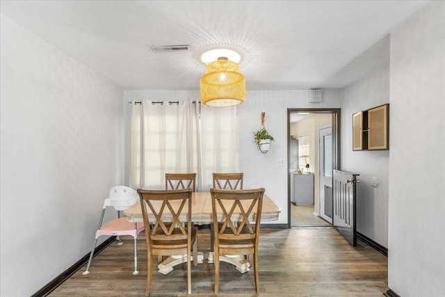 dining area featuring dark wood-type flooring