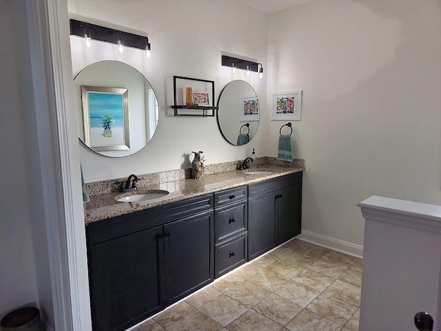 full bath featuring double vanity, a sink, and baseboards