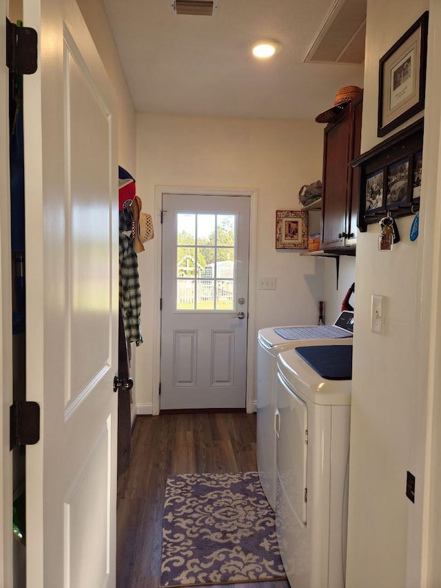 laundry area featuring cabinet space, dark wood finished floors, and washing machine and clothes dryer