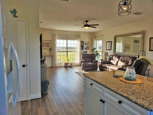 kitchen featuring open floor plan, visible vents, dark wood finished floors, and white cabinetry