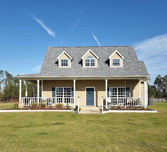 view of front facade featuring covered porch, central AC, a front lawn, and a shingled roof