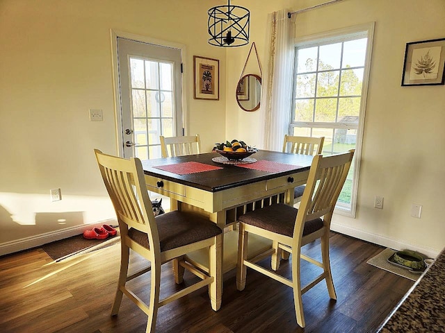 dining area featuring dark wood finished floors and baseboards