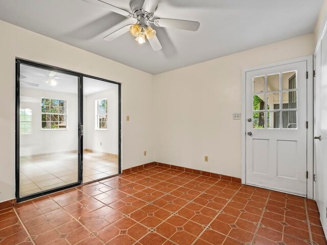 tiled empty room featuring ceiling fan