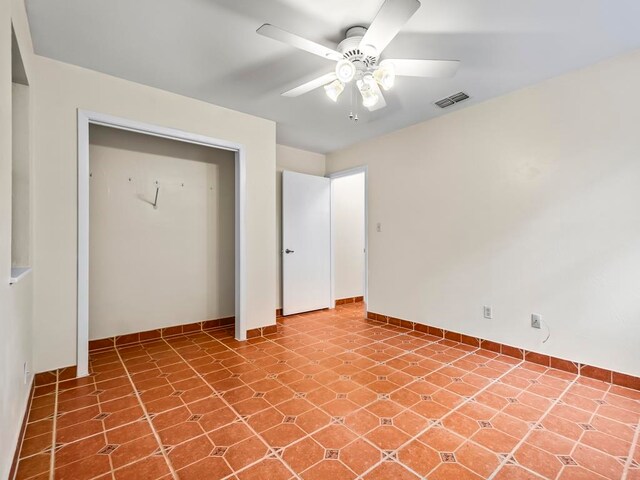 unfurnished bedroom with ceiling fan and a closet