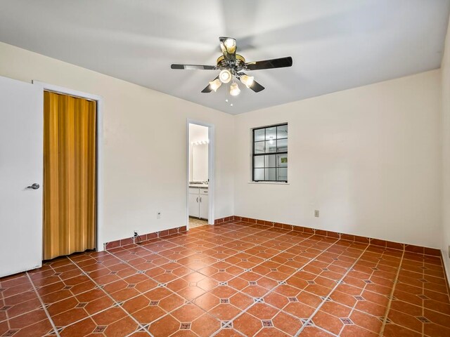 tiled spare room with ceiling fan