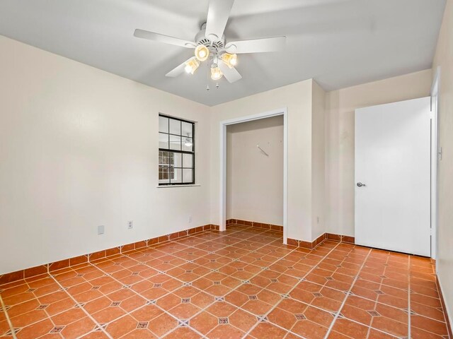 unfurnished bedroom with ceiling fan and a closet