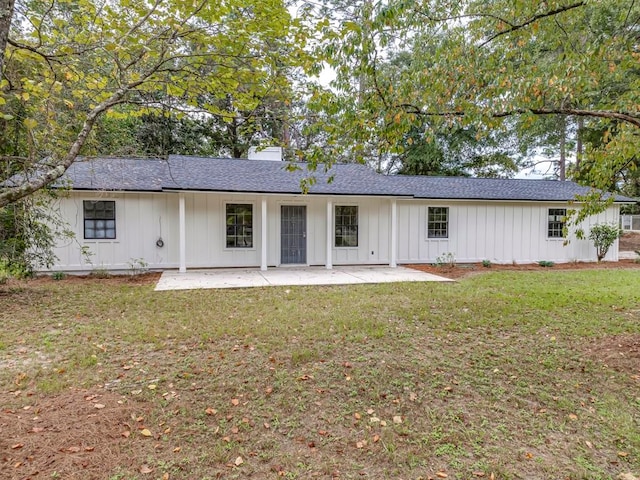 rear view of property featuring a patio area and a lawn