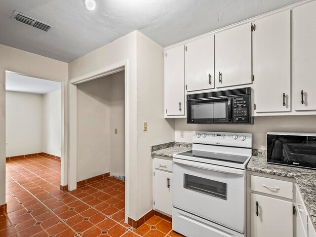 kitchen featuring white electric stove, light stone countertops, tile patterned floors, and white cabinets