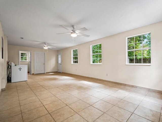 tiled spare room featuring ceiling fan