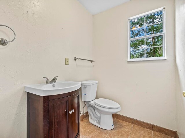 bathroom with tile patterned flooring, vanity, and toilet