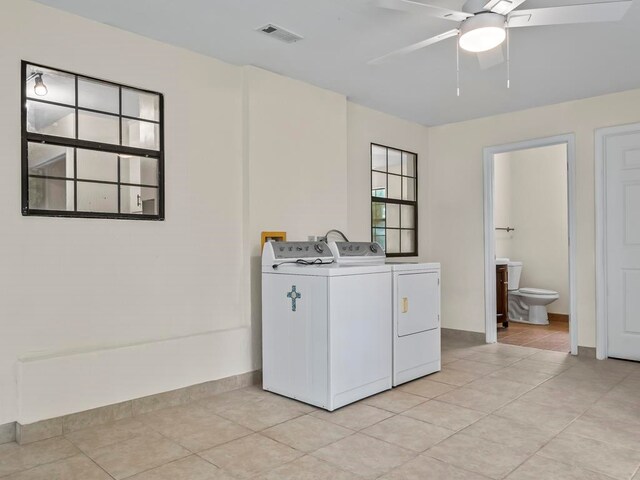 laundry room with ceiling fan, separate washer and dryer, and light tile patterned floors