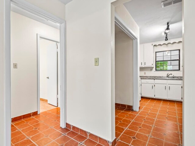 hallway featuring light tile patterned flooring and sink