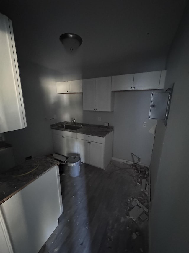 kitchen featuring sink, white cabinetry, and dark stone countertops