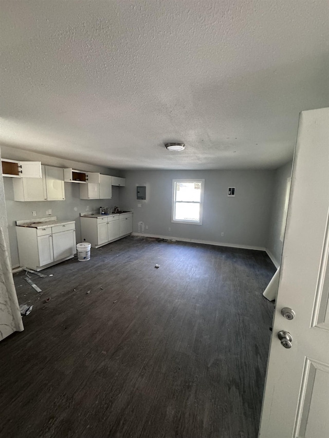 unfurnished living room featuring dark hardwood / wood-style flooring and a textured ceiling