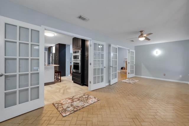 spare room featuring ceiling fan and french doors