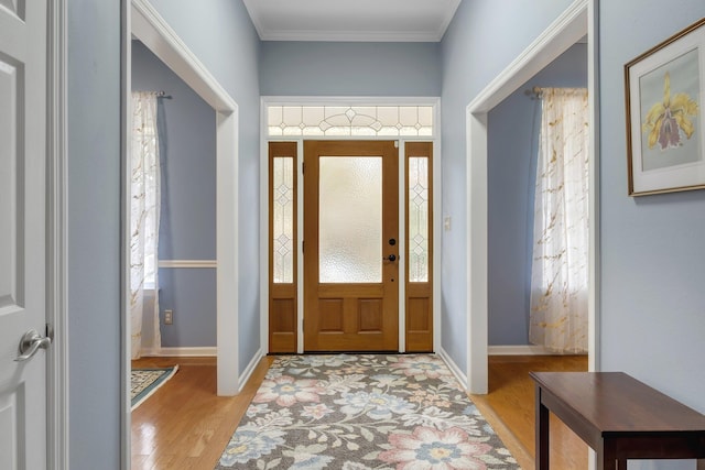 entrance foyer with ornamental molding and light wood-type flooring