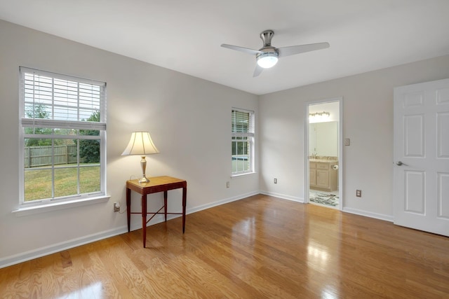 unfurnished room with a wealth of natural light, ceiling fan, and light wood-type flooring