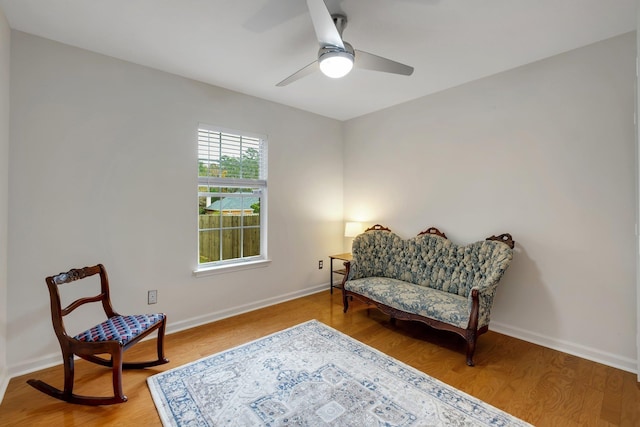 sitting room with hardwood / wood-style floors and ceiling fan