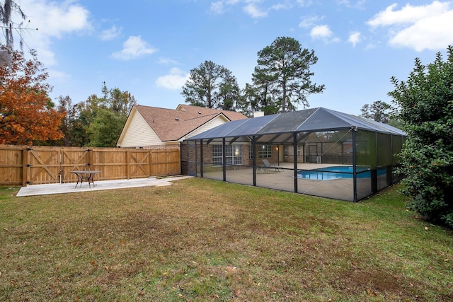 view of yard featuring a fenced in pool, a patio area, and glass enclosure