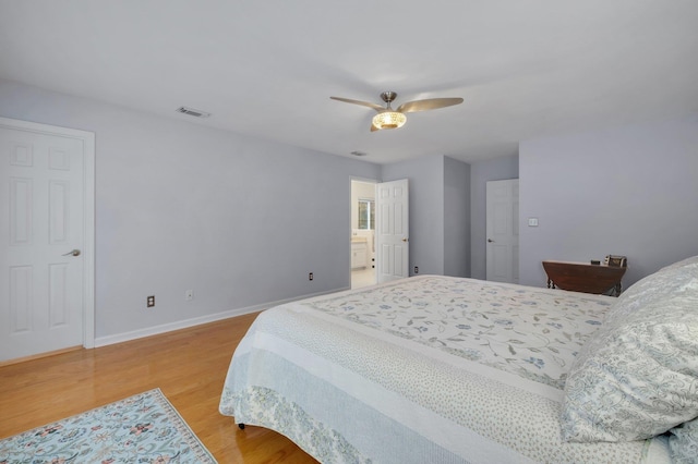 bedroom featuring ensuite bath, ceiling fan, and light wood-type flooring