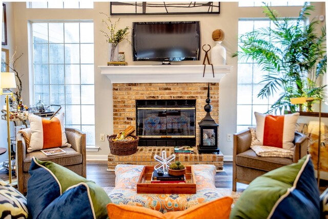 living room with baseboards, wood finished floors, and a fireplace