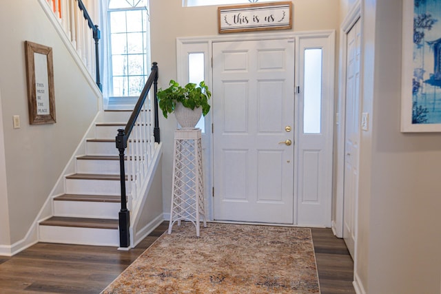 foyer with dark wood-style floors, stairs, and baseboards