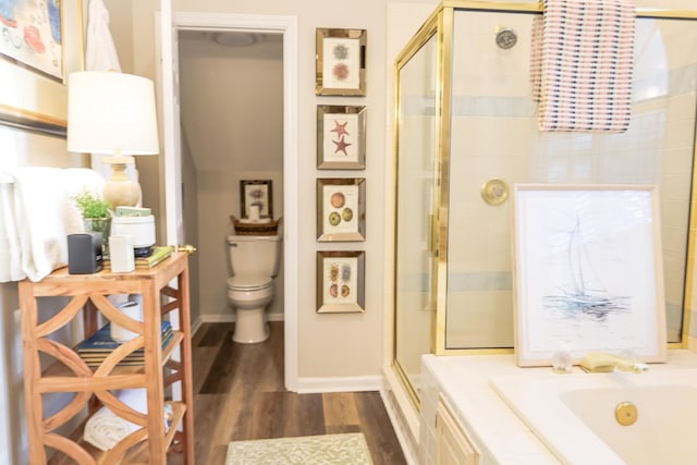 full bath with wood finished floors, a garden tub, a stall shower, and toilet