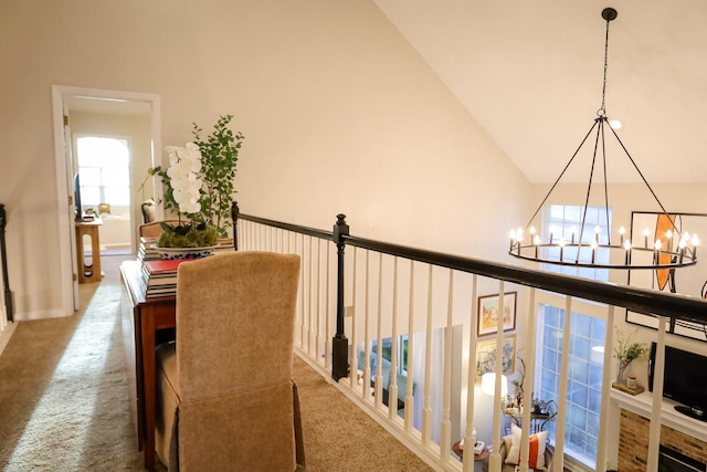 hallway featuring high vaulted ceiling, carpet, and a chandelier